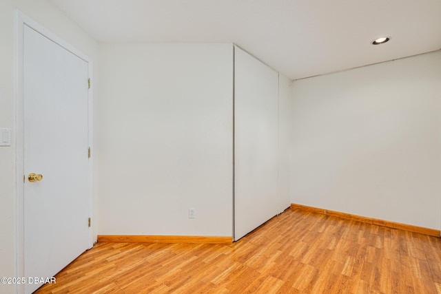 empty room featuring light wood-style floors, baseboards, and recessed lighting