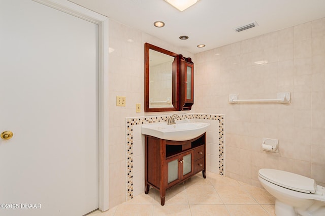 bathroom featuring visible vents, vanity, tile patterned flooring, and tile walls