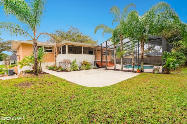 back of property featuring a lanai, a yard, a fenced in pool, stucco siding, and a patio area