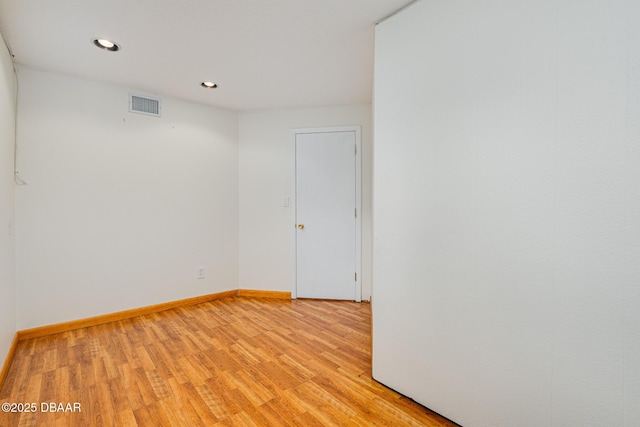 empty room featuring light wood-style flooring, recessed lighting, visible vents, and baseboards