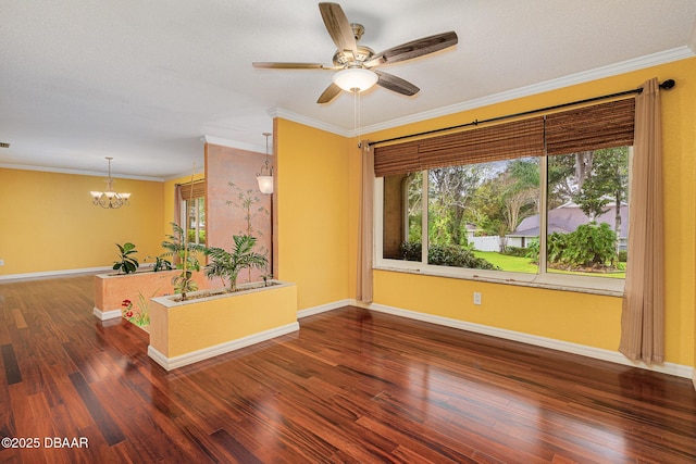 empty room with baseboards, wood finished floors, and crown molding