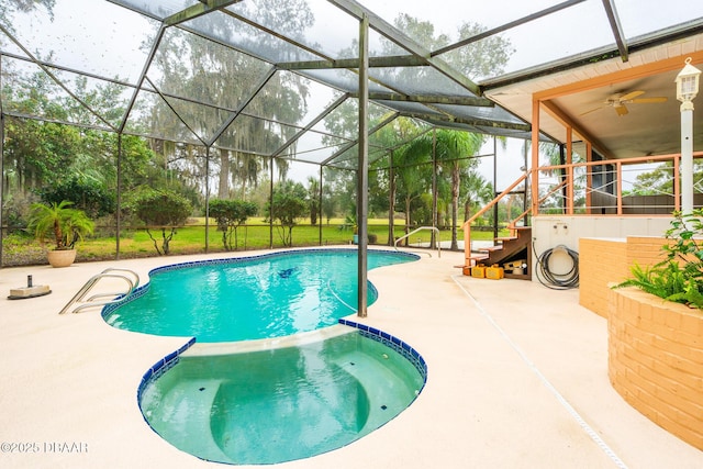 view of swimming pool with glass enclosure, a pool with connected hot tub, and a patio