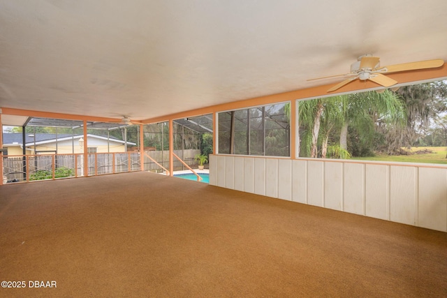 unfurnished sunroom with ceiling fan