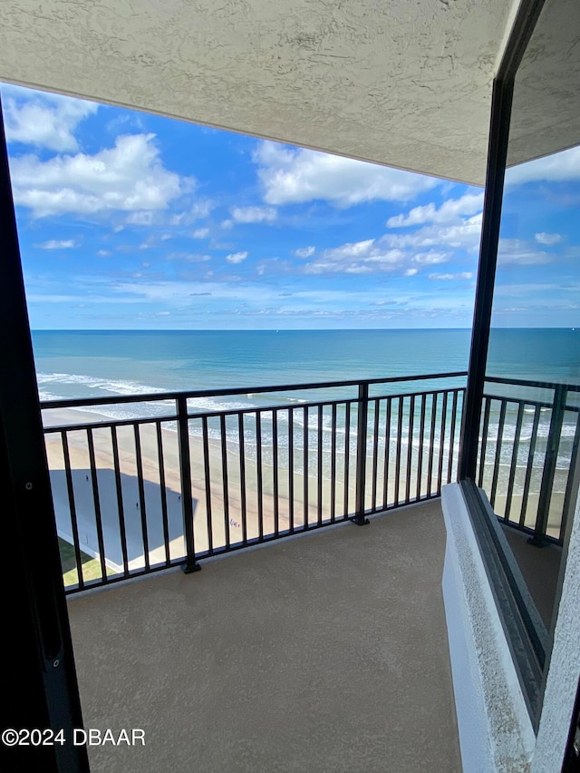 balcony featuring a beach view and a water view