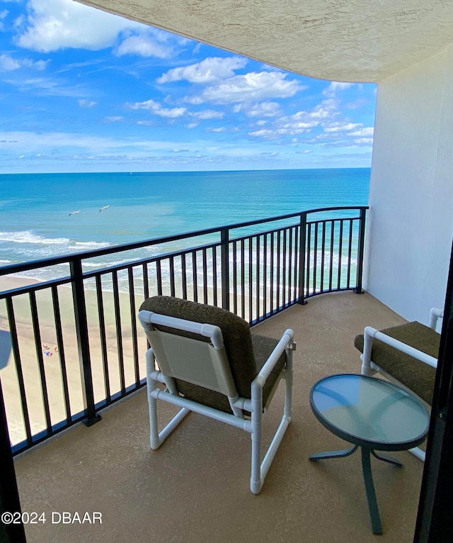 balcony featuring a beach view and a water view