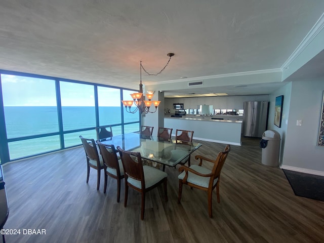 dining room with a water view, ornamental molding, expansive windows, a notable chandelier, and dark wood-type flooring