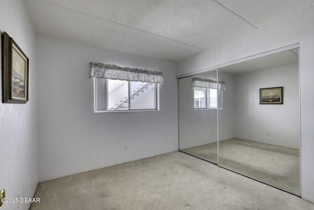 405 N Halifax Ave N Unit 208, Daytona Beach, FL 32118 - unfurnished bedroom featuring a textured ceiling, carpet, and a closet