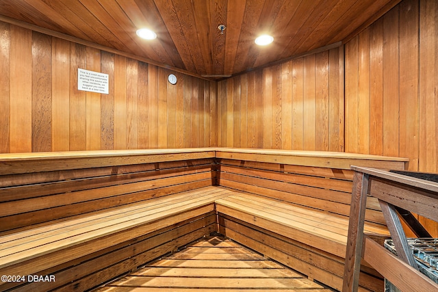 view of sauna / steam room with wood-type flooring, wooden walls, and wood ceiling