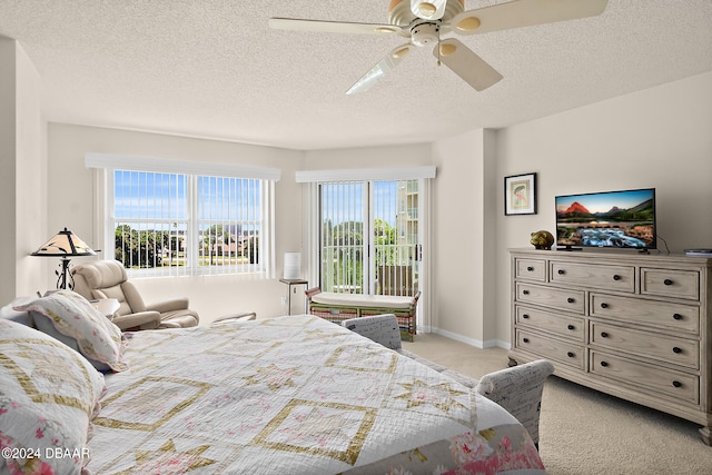 bedroom featuring a textured ceiling, multiple windows, light carpet, and ceiling fan