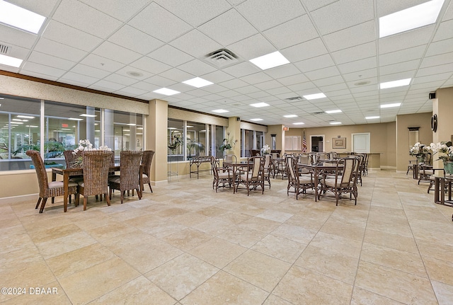 tiled dining room featuring a drop ceiling