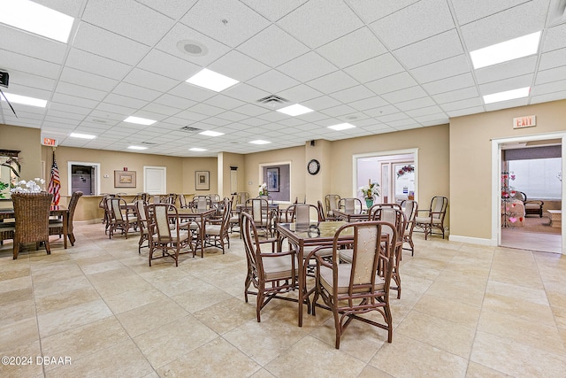 tiled dining space with a paneled ceiling