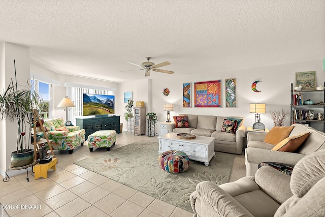 living room featuring a textured ceiling, light tile patterned floors, and ceiling fan