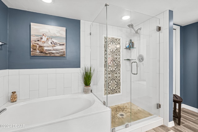 bathroom with shower with separate bathtub and wood-type flooring