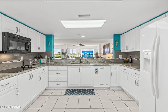 kitchen with kitchen peninsula, black appliances, sink, backsplash, and white cabinetry