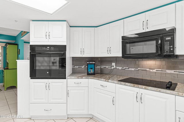 kitchen with white cabinetry, black appliances, light tile patterned floors, and tasteful backsplash