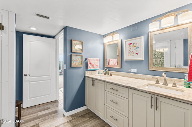 bathroom with walk in shower, vanity, and hardwood / wood-style flooring