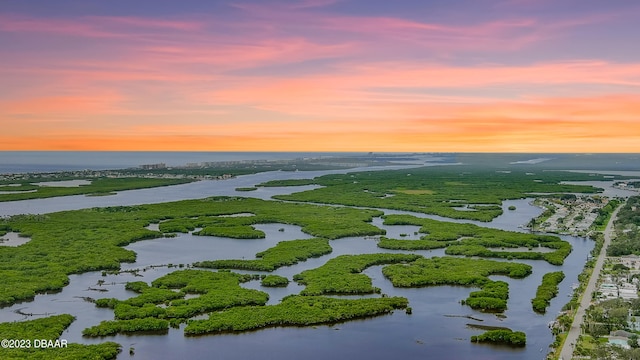 aerial view at dusk featuring a water view