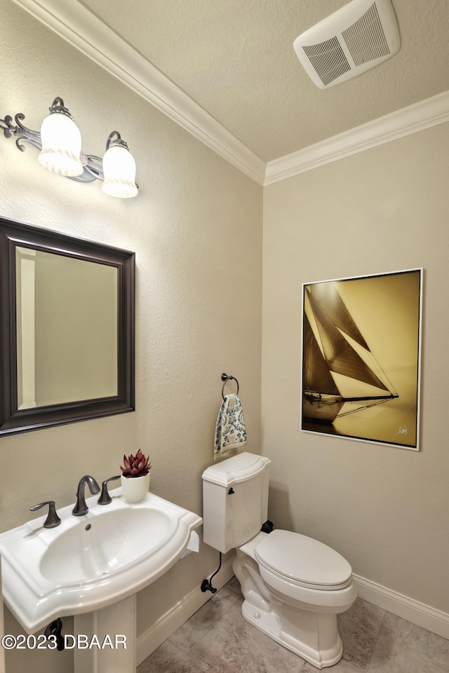 bathroom with tile patterned flooring, sink, a textured ceiling, crown molding, and toilet