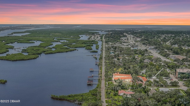 aerial view at dusk featuring a water view