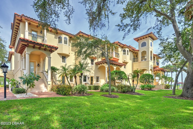 exterior space with a balcony and a front yard