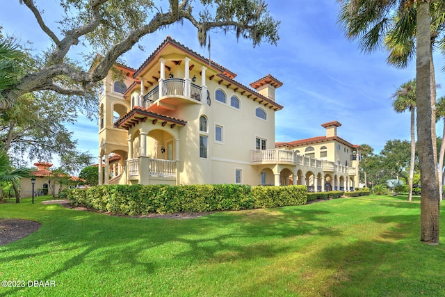 view of front facade featuring a front yard and a balcony