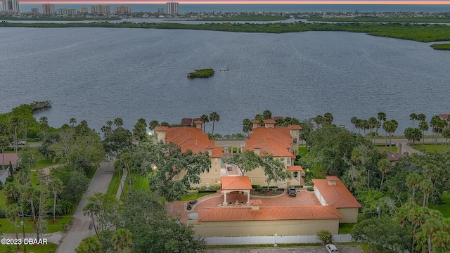 aerial view at dusk featuring a water view