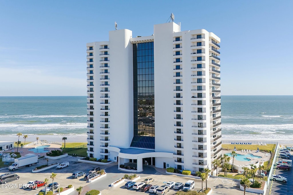 view of property with a beach view and a water view