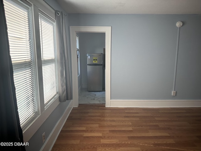 empty room with dark hardwood / wood-style flooring