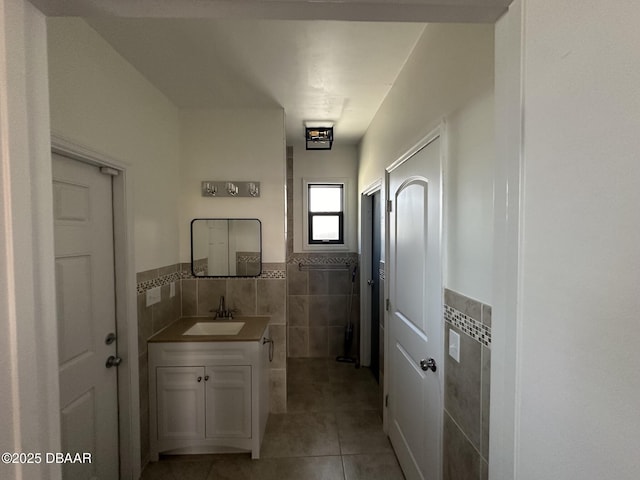 bathroom with vanity, tile patterned floors, and tile walls