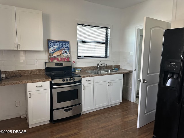 kitchen featuring stainless steel range, white cabinetry, black fridge, and sink