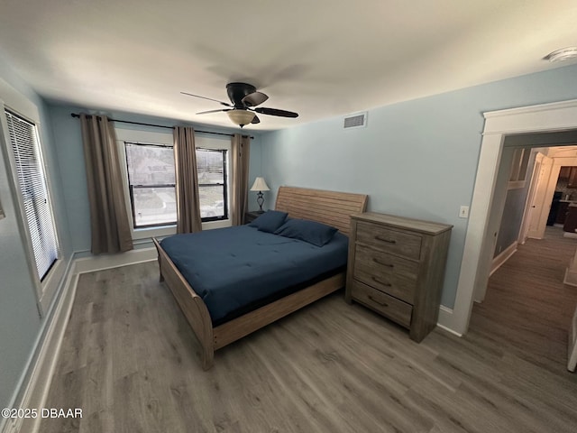 bedroom with dark hardwood / wood-style floors and ceiling fan