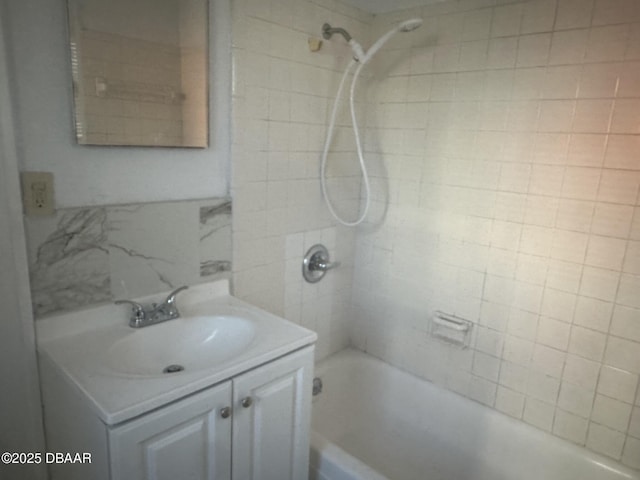 bathroom with tiled shower / bath combo and vanity