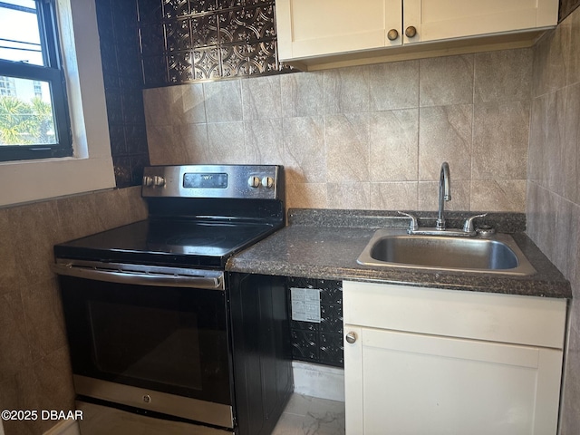 kitchen with white cabinets, sink, and electric stove