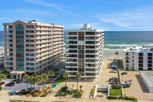 view of building exterior with a water view and a view of the beach