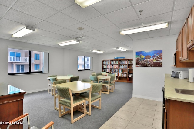 tiled dining area featuring a paneled ceiling