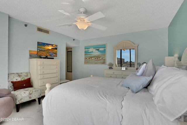 bedroom featuring ceiling fan and a textured ceiling