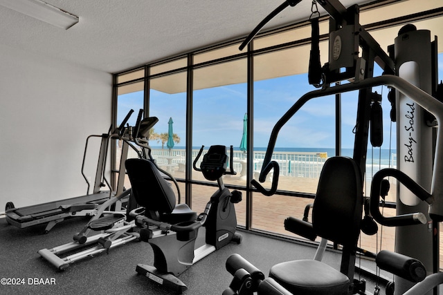 gym with a healthy amount of sunlight, a water view, and floor to ceiling windows