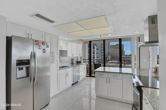 kitchen featuring white cabinetry, sink, range hood, and appliances with stainless steel finishes