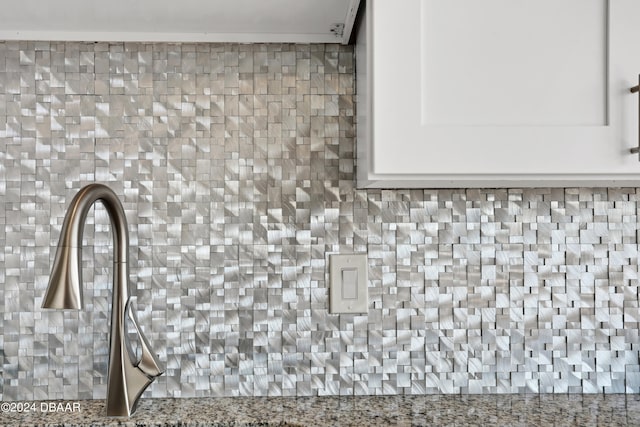 details with white cabinets, backsplash, and light stone countertops