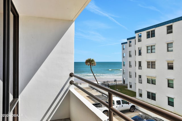 balcony featuring a view of the beach and a water view