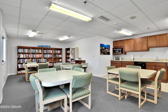 dining area with a drop ceiling, carpet, and sink