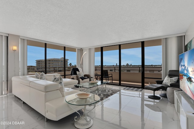 living room featuring a textured ceiling, a wall of windows, and a healthy amount of sunlight