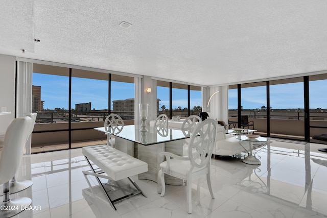 dining area featuring a wall of windows and a textured ceiling