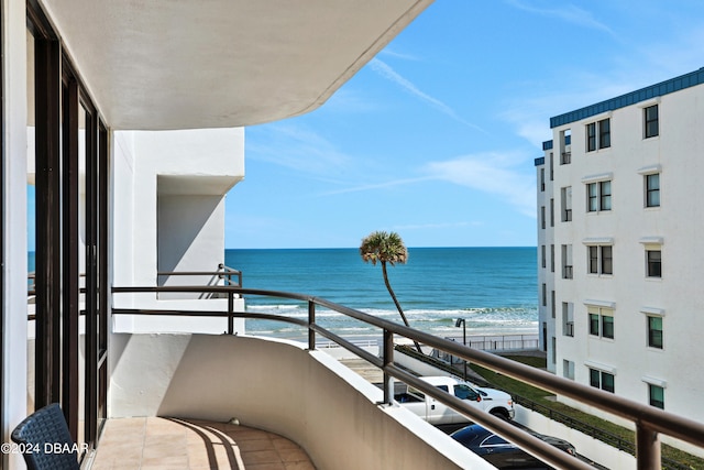 balcony featuring a water view and a beach view