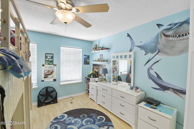 walk in closet featuring light wood finished floors and ceiling fan