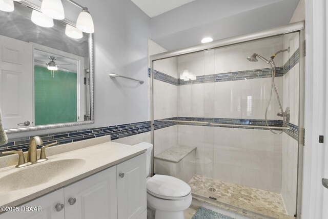 full bath with backsplash, a shower stall, toilet, and vanity