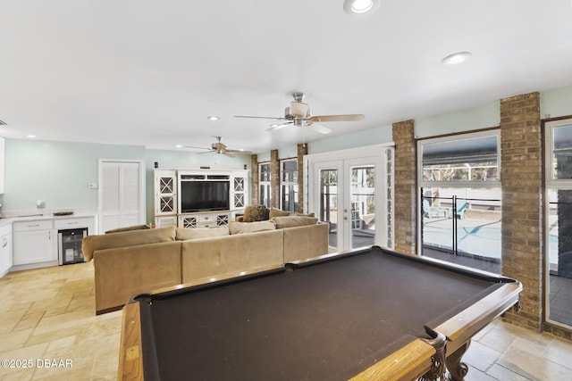 game room with recessed lighting, french doors, wine cooler, and stone tile floors