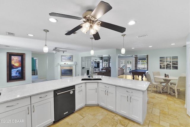 kitchen with dishwashing machine, visible vents, stone tile flooring, pendant lighting, and open floor plan