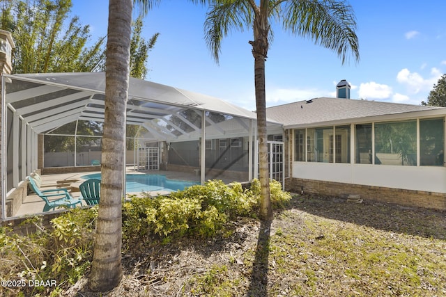 pool featuring glass enclosure and a patio