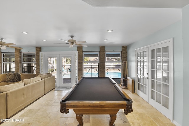 rec room featuring stone tile floors, plenty of natural light, french doors, and billiards